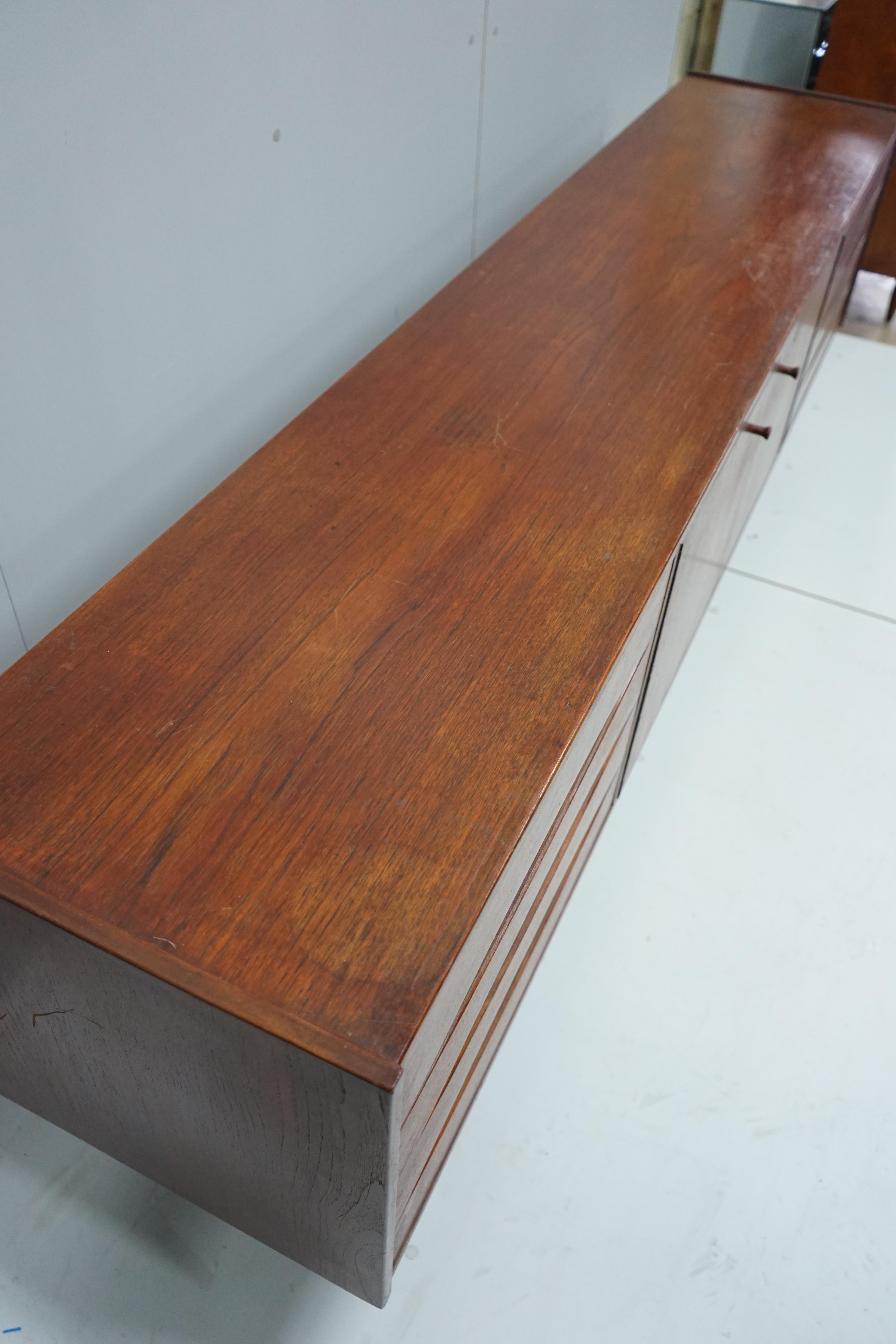 In the manner of Arne Vodder, a mid century teak sideboard width 221cm, depth 45cm, height 73cm.